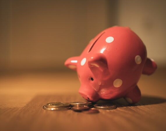 pink pig coin bank on brown wooden table