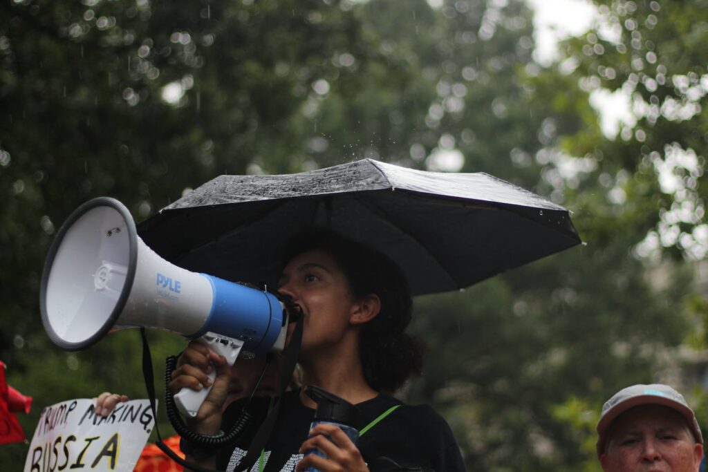 投資前,你必須知道的五件事-4個美元保單的秘密風險 1 woman standing holding umbrella and white megaphone during daytime