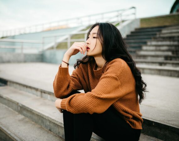 woman wearing brown sweater holding lips