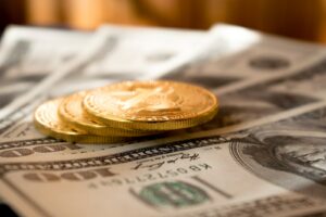 智慧理財,開創財富未來 27 three round gold-colored coins on 100 US dollar banknotes