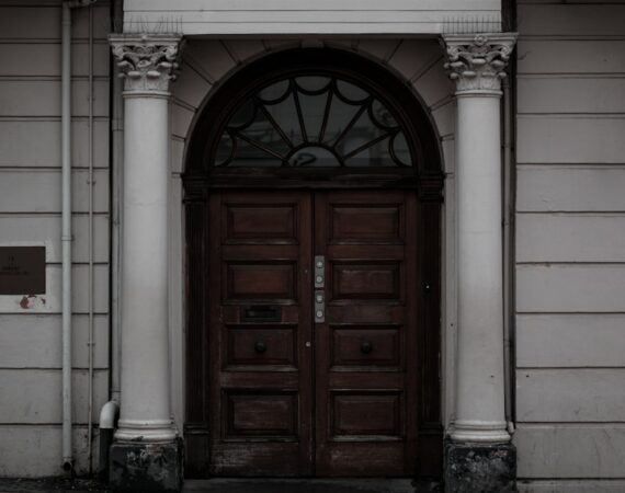 brown wooden door on white concrete building